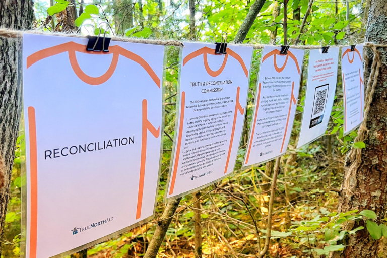 reconciliation walk information on pages hung up on a string in a forest