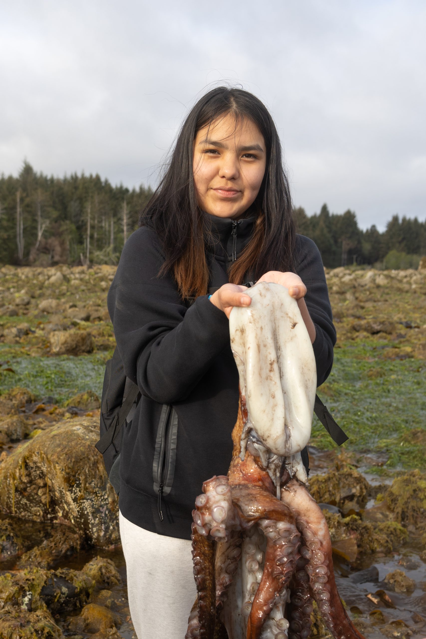 girl from Kitasoo Xai'Xais Nation holding an octopus in Haida Gwaii, British Columbia