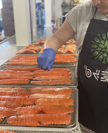 A chef tending to platters of raw meat
