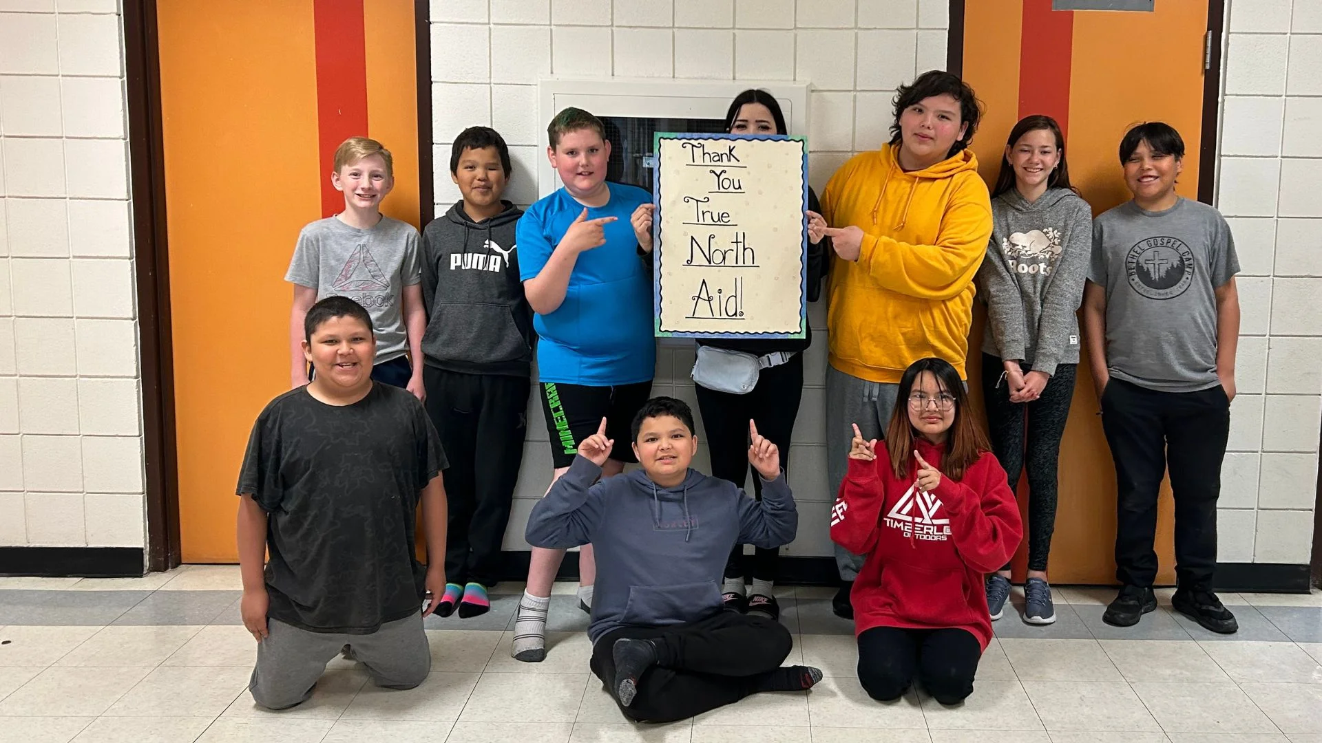 school in saskatchewan holding a thank you true north aid sign